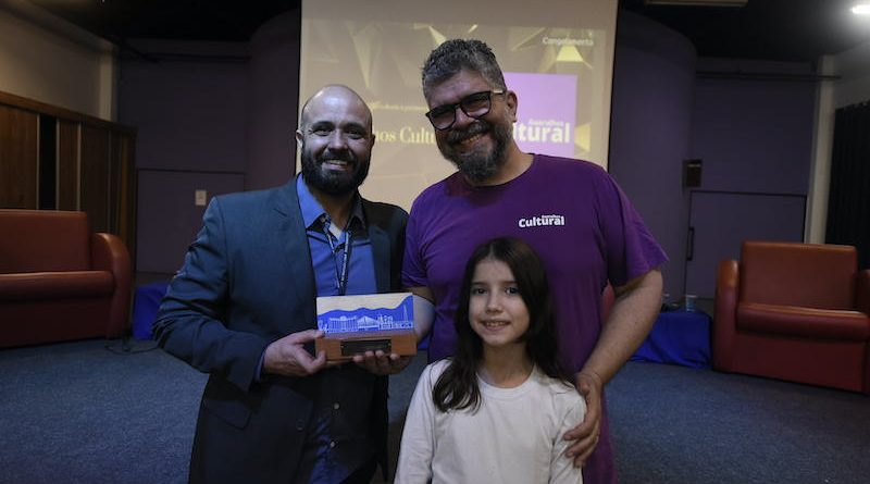 O Diretor Executivo da Guarulhos Cultural, Vitor Souza, juntamente com sua filha Lorena Buzato, recebem o Prêmio Prêmio Luis Figueira de Quental 2022 na Categoria Comunicação das mãos do Diretor de Turismo de Guarulhos, Ricardo Balcone.